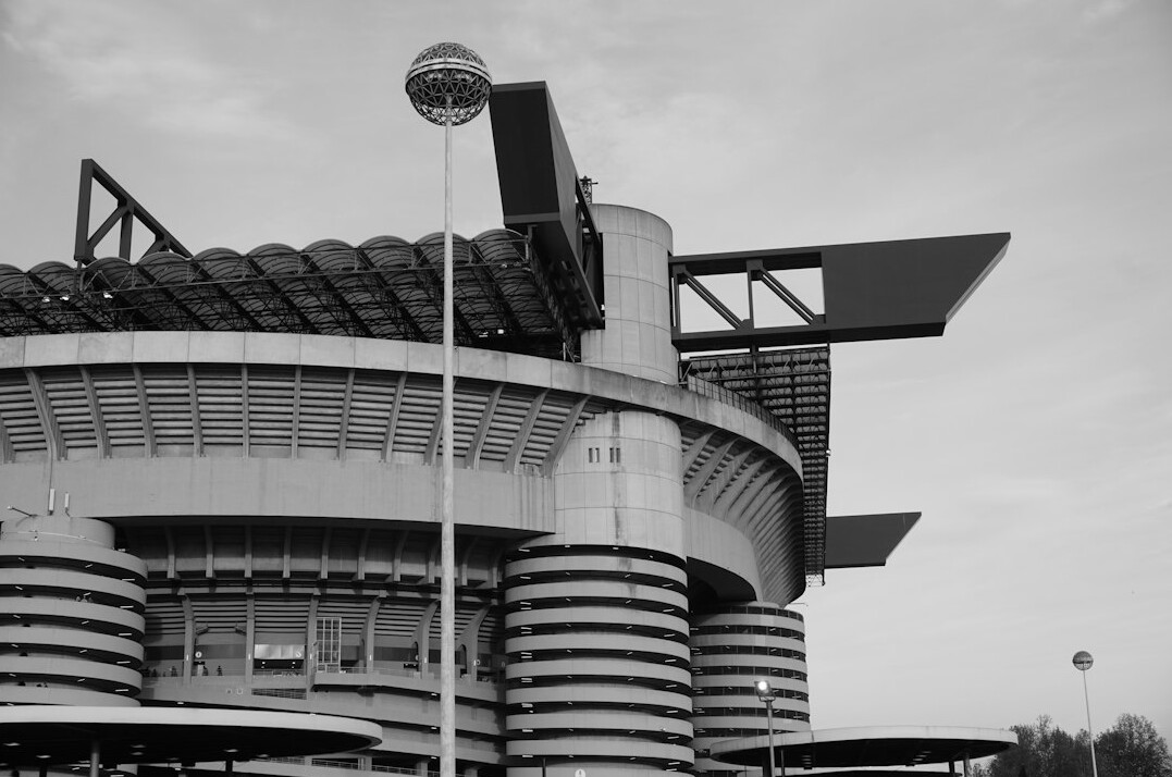 Outside broadcast satellite truck parked outside a stadium with satellite dish extended